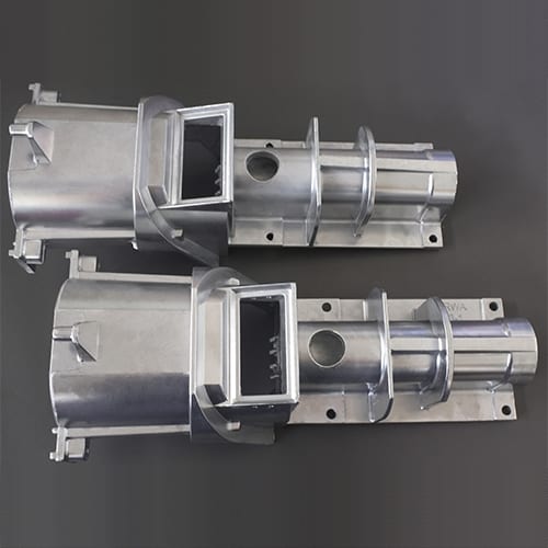 The image shows a pair of metal parts on a gray background, which appear to be part of a CNC milling machine. The metal parts are silver in color and have a glossy finish.